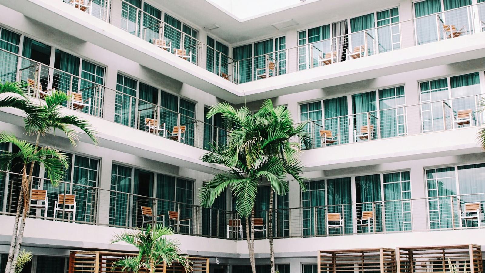 Hotel courtyard with balconies and palm trees
