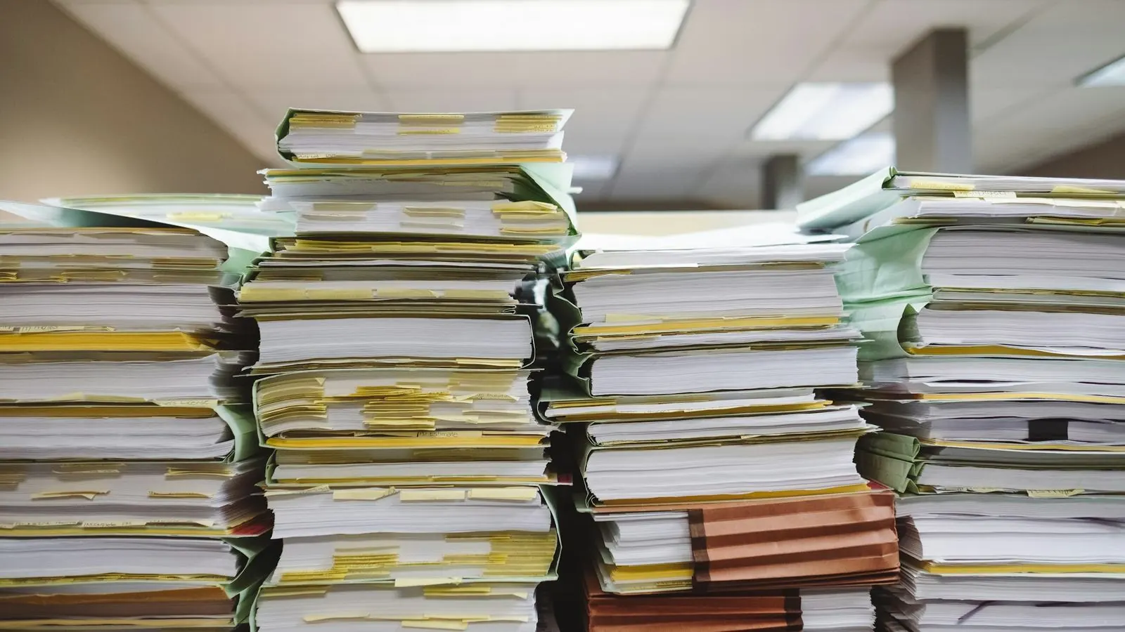 Tall stacks of billing files and invoices awaiting reconciliation