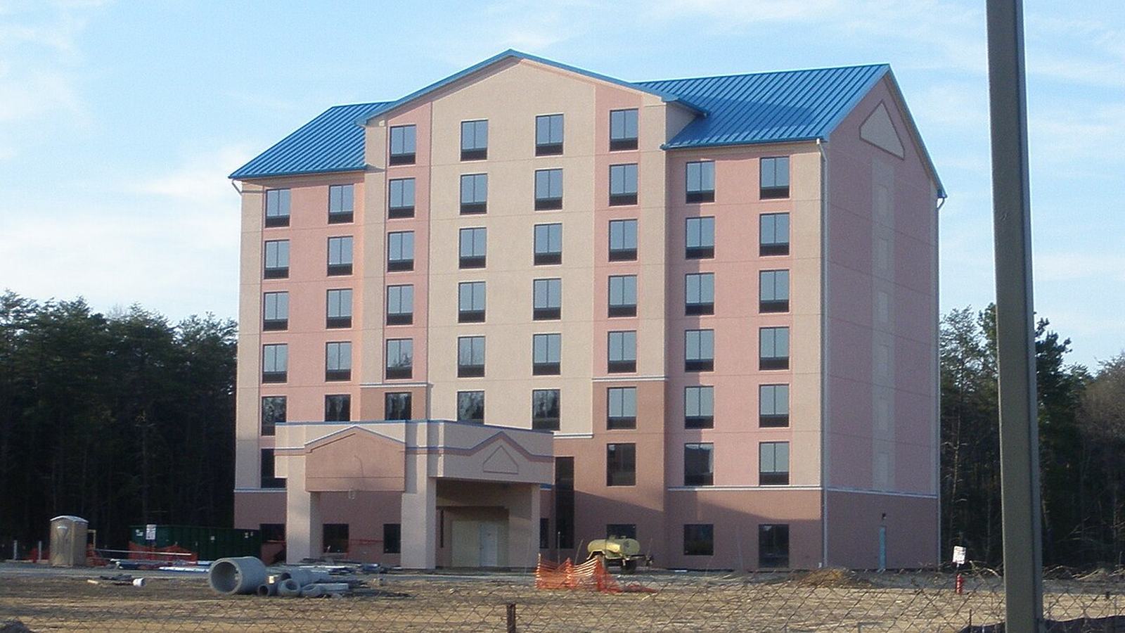 Unbranded hotel building nearing completion at a highway exit