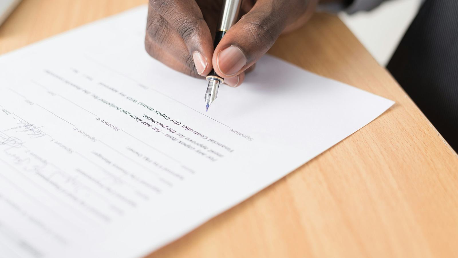 Hand signing a printed agreement with a fountain pen