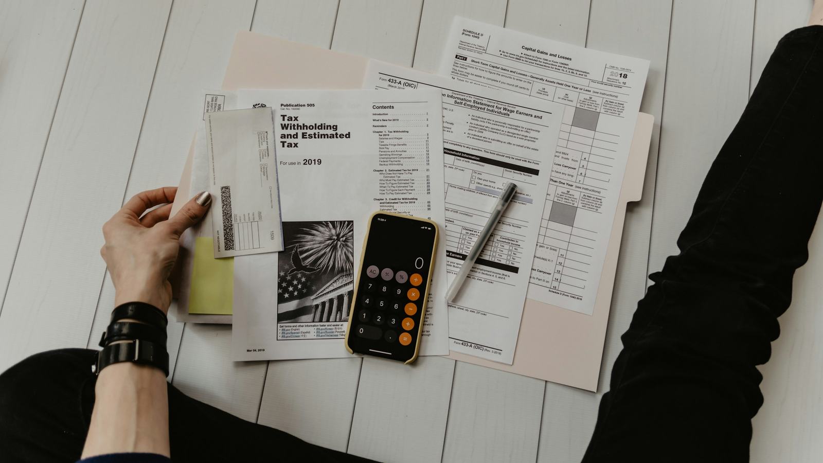 Person reviewing billing paperwork with a calculator