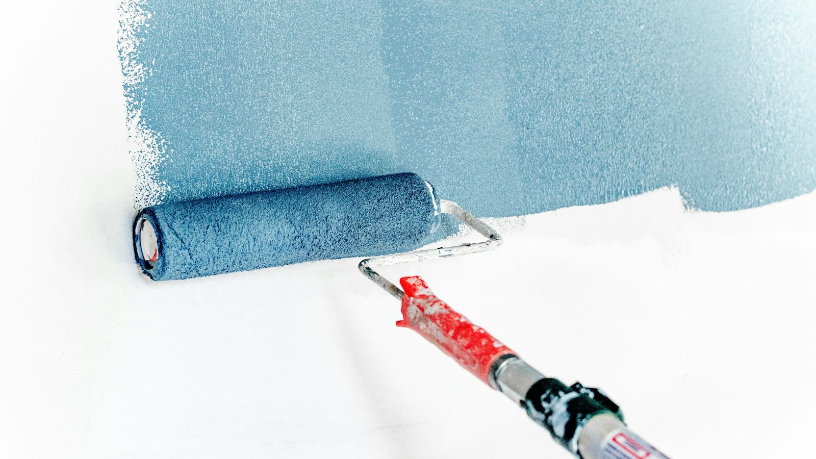 Paint roller applying a fresh color to a wall during renovation