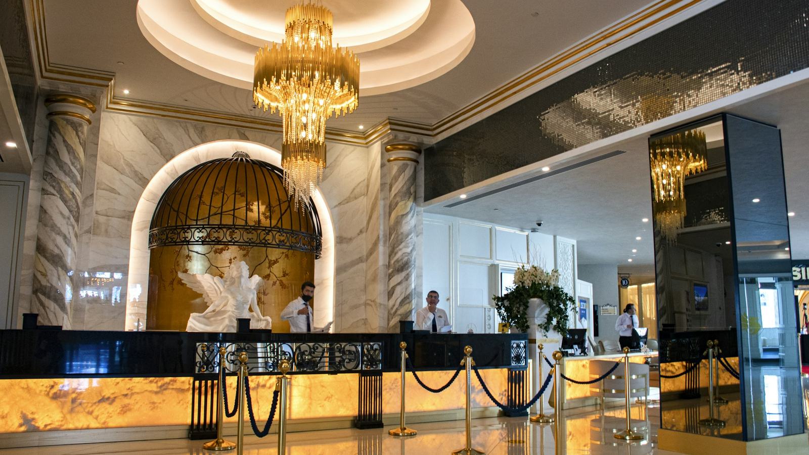 Upscale hotel lobby with chandelier and reception desk