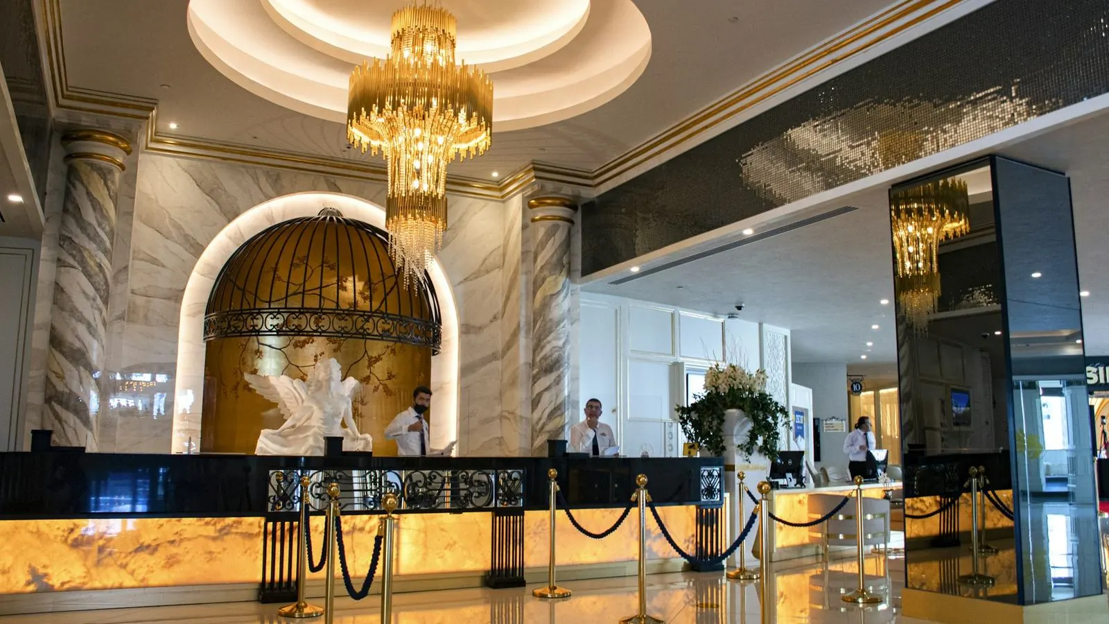 Upscale hotel lobby with chandelier and reception desk