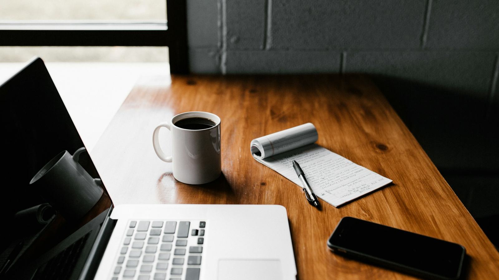 Laptop, smartphone and coffee on a wooden desk