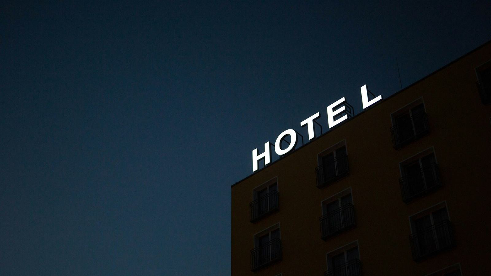 Illuminated hotel sign on a building at night