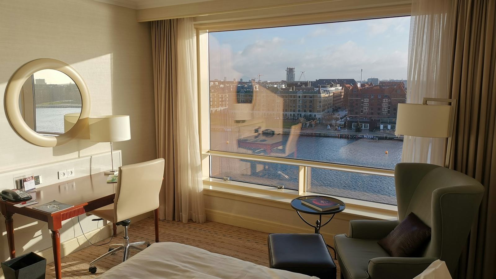 Hotel guest room with work desk and window view of the city