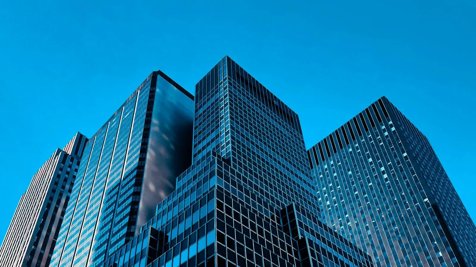 Glass office towers against a blue sky